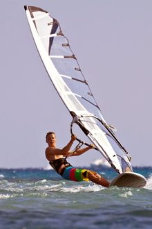 Zwei Surfer hängen im Trapez an ihrem Windsurfboard