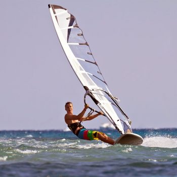 Zwei Surfer hängen im Trapez an ihrem Windsurfboard