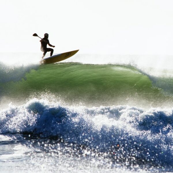 Ein SUP in der Welle beim surfen