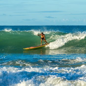 SUP Surfer in der Welle